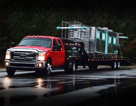 Red dually with gooseneck flatbed trailer hauling hot shot freight